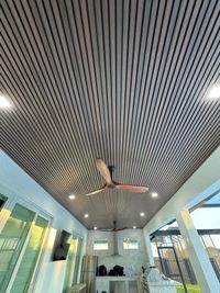 Patio Ceiling with Stylish Wooden Slats and Fans: An outdoor patio with a sophisticated ceiling design made of horizontal wooden slats, complemented by modern fans and ambient recessed lighting for a luxurious feel.