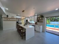 Sophisticated kitchen boasting dual ovens, a farmhouse sink, and a stunning blue mosaic backsplash for a bold yet cohesive design.