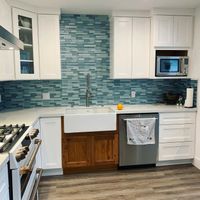 Classic white kitchen with clean subway tile backsplash, traditional cabinetry, and polished stone countertops for a timeless design.