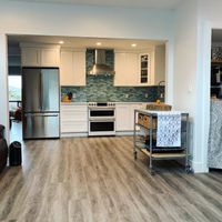 Contemporary kitchen featuring a stylish textured island with ambient lighting, complemented by sleek cabinetry and stainless steel appliances.